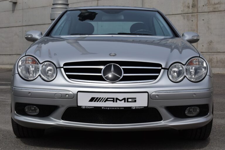 Front view of a silver Mercedes-Benz AMG sports car parked in front of a concrete wall.