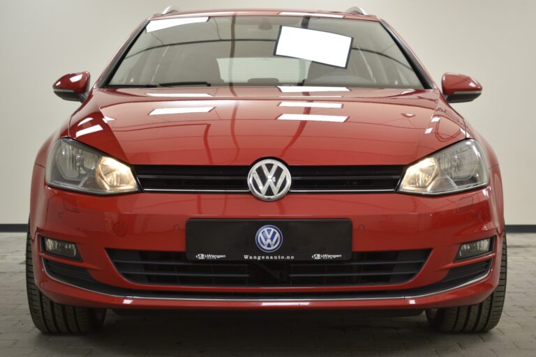 Front view of a red Volkswagen car displayed in a showroom with a visible Volkswagen logo on the grille.