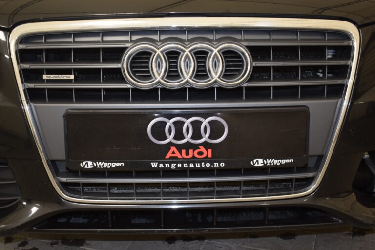 Close-up of an Audi car grille featuring the Audi logo and a license plate labeled Wangenauto.no.