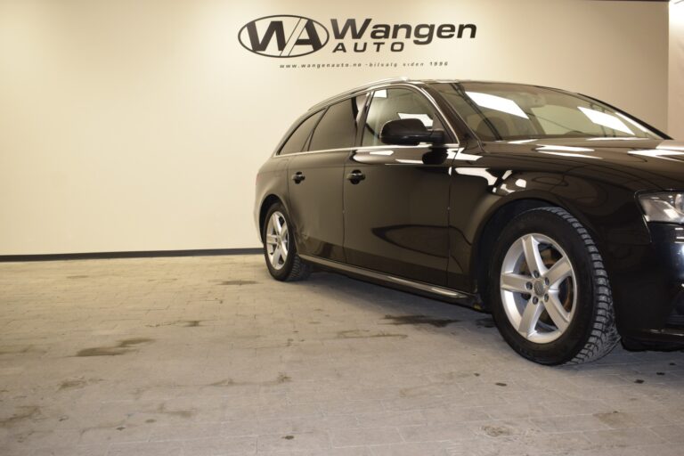 Black station wagon parked on tiled showroom floor next to a wall with "Wangen Auto" logo.