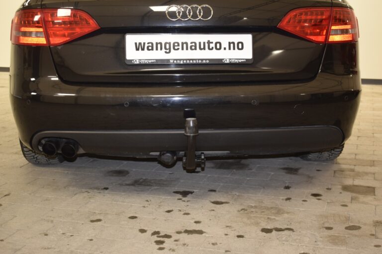 Rear view of a black Audi vehicle with a tow hitch, parked on a tiled surface. The license plate displays "wangenauto.no".