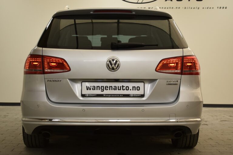 Rear view of a silver Volkswagen Passat 2.0 TDI with tail lights on, parked indoors. The license plate reads "wangenauto.no".