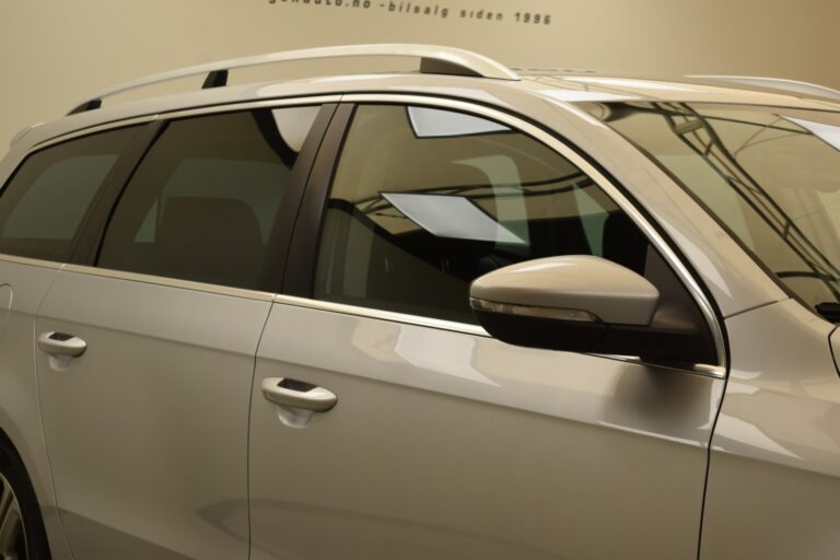 A close-up view of the passenger side of a silver SUV, showcasing its windows, side mirror, and a portion of the door handle.