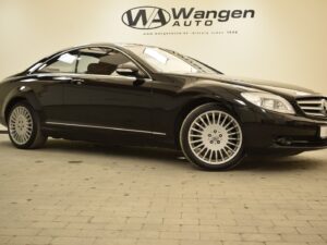 A black luxury car is parked inside a showroom with the "WA Wangen Auto" sign on the wall behind it.