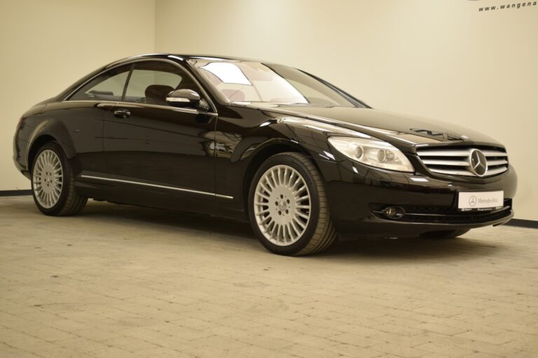 A black luxury coupe car is parked indoors on a tiled flooring.