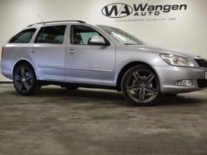 A silver station wagon parked indoors on a tiled floor, with "Wangen Auto" signage in the background.