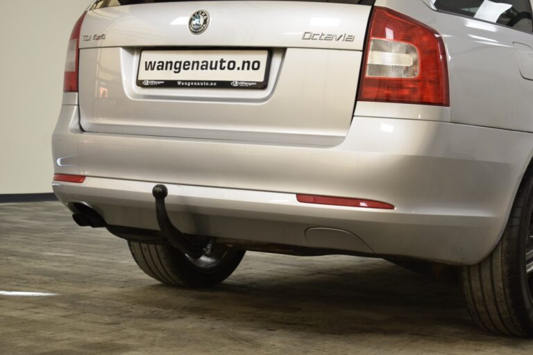 Rear view of a silver Skoda Octavia with a tow hitch, parked indoors. The license plate reads "wangenauto.no".