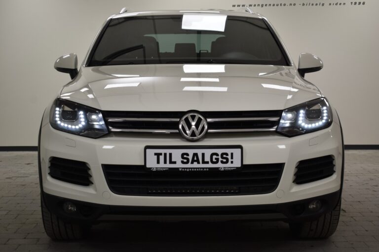 Front view of a white Volkswagen SUV with a sign reading "Til Salgs!" in Norwegian on the license plate, indicating it is for sale.