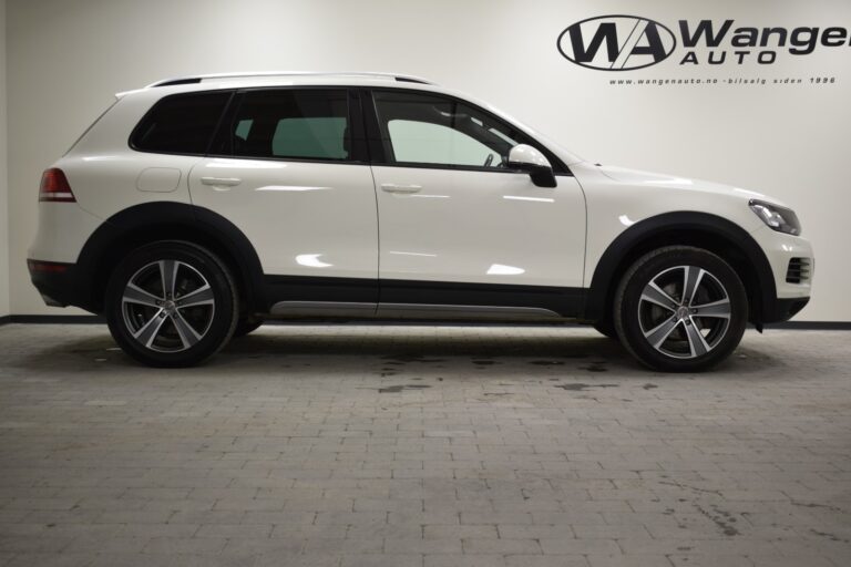 Side view of a white SUV parked indoors with the "Wange Auto" logo on the wall in the background.