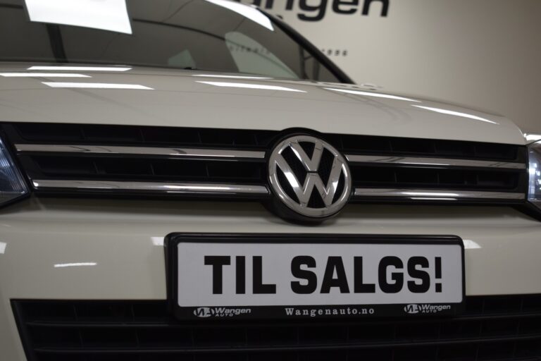 Close-up of the front grille of a white Volkswagen vehicle with a license plate reading "TIL SALGS!" indicating the car is for sale.