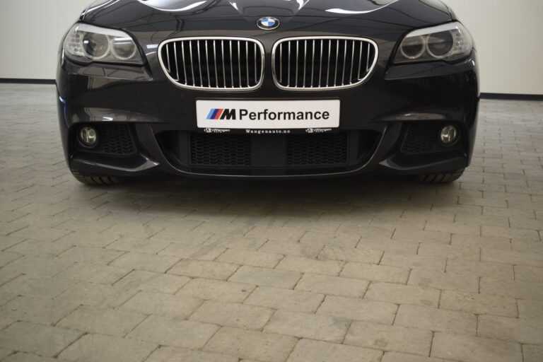 Front view of a black BMW sedan with an "M Performance" license plate, parked on a paved surface.