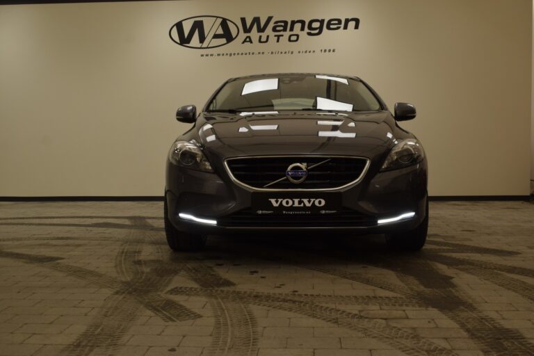 Front view of a Volvo car inside Wangen Auto dealership showroom with a beige wall in the background.