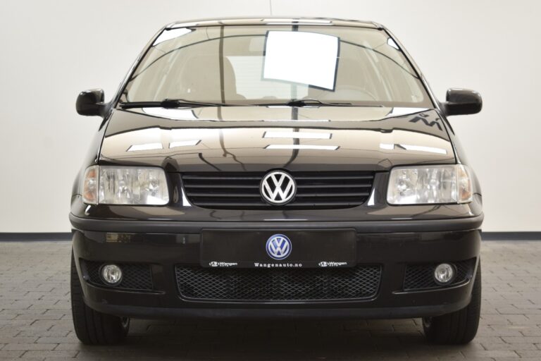 Front view of a black Volkswagen car parked on a tiled floor against a white background. The vehicle has the VW logo on the grille and rectangular headlights.