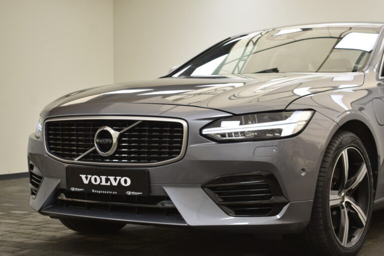 Front view of a gray Volvo car parked indoors, focusing on the grille, headlights, and bumper.