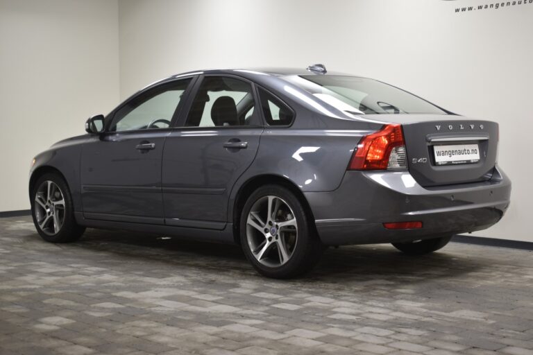 A gray Volvo S40 is parked indoors on a tiled floor, viewed from the rear left corner.