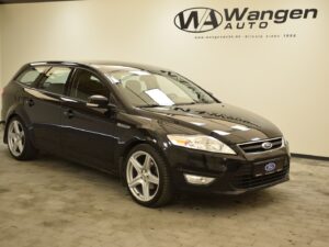 A black Ford station wagon parked indoors at Wangen Auto.