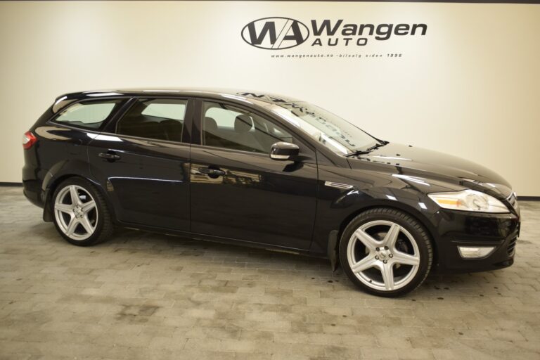 A black Ford station wagon parked in a showroom with a sign "Wangen Auto" on the wall in the background.