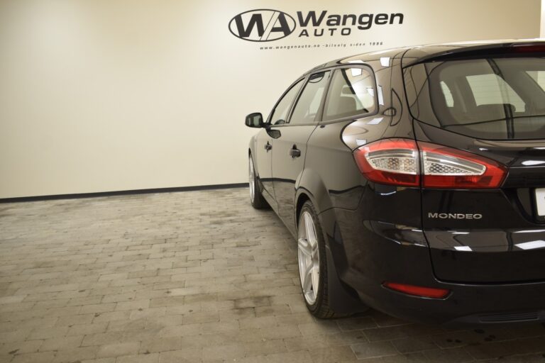 A black Ford Mondeo is parked indoors on a tiled floor, with a Wangen Auto sign on the wall in the background.