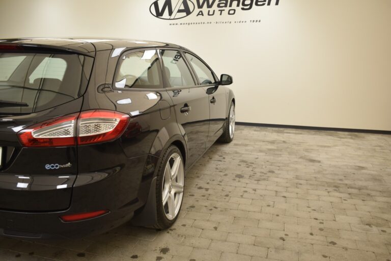 A black station wagon with the logo "ecoBoost" is parked on a tiled floor inside a showroom with "Wangen Auto" branding on the wall in the background.